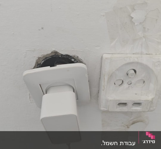 שקע חשמל עם תקע בקיר לבן